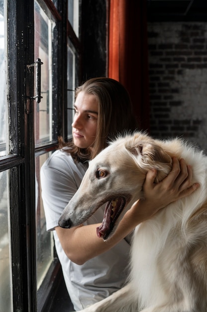 Photo gratuite homme de coup moyen avec un mignon chien lévrier