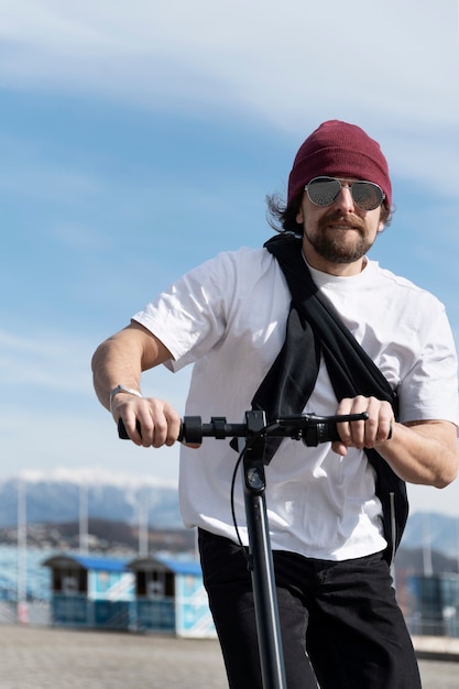 Homme de coup moyen avec scooter électrique