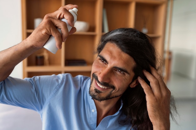 Photo gratuite homme à coup moyen utilisant du shampoing sec à la maison