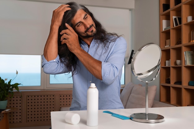 Homme à coup moyen utilisant du shampoing sec à la maison