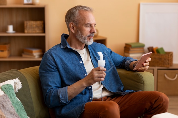 Photo gratuite homme de coup moyen utilisant un nébuliseur