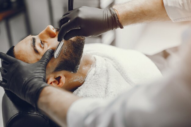 L&#39;homme coupe sa barbe dans le salon de coiffure.