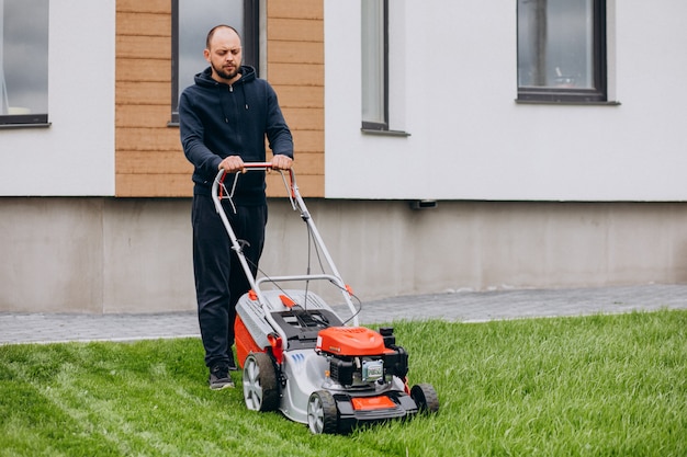 Homme, couper herbe, à, tondeuse gazon, dans, les, arrière-cour