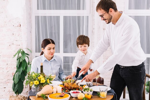 Homme, couper, poulet cuit, à, table