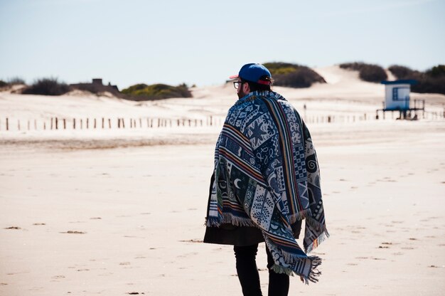 Homme Avec Couverture Marchant Sur La Plage