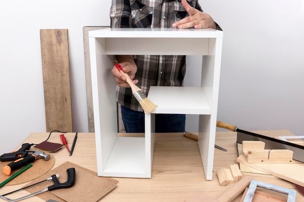 Homme créant une armoire à partir de la vue de face en bois