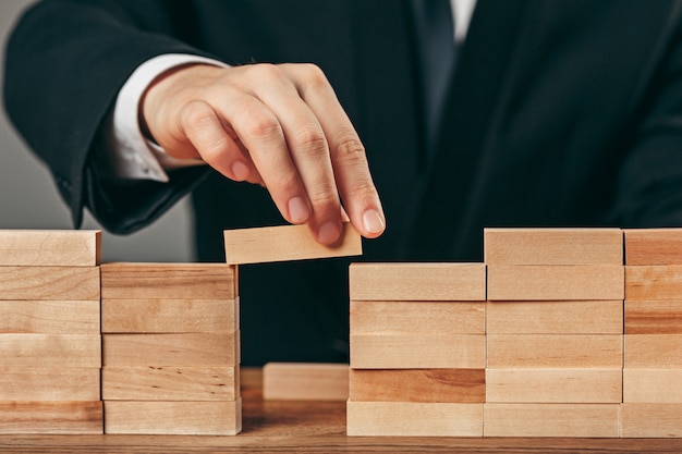 Homme et cubes en bois sur table. Concept de gestion