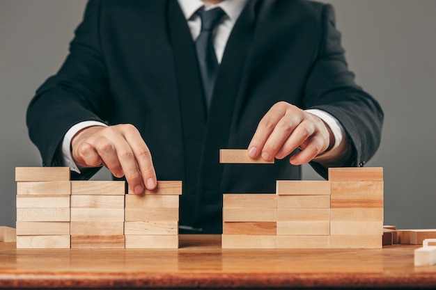 Homme et cubes en bois sur table. Concept de gestion