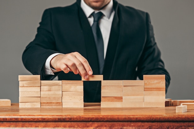 Homme et cubes en bois sur table. Concept de gestion