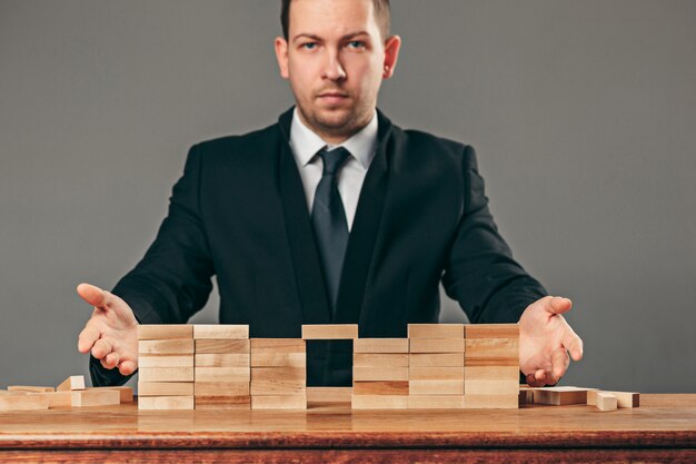 Homme et cubes en bois sur table. Concept de gestion