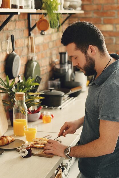 Homme cuisinant dans la cuisine. Petit déjeuner le matin