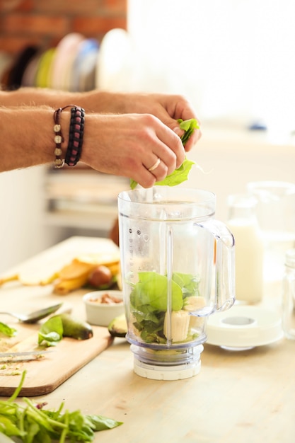 Homme cuisinant avec un mélangeur