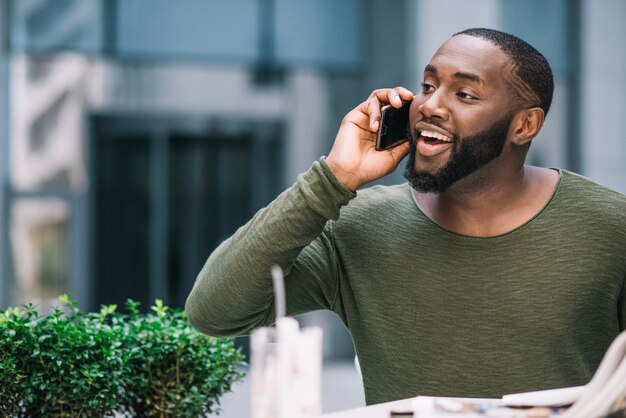 Homme curieux parlant au téléphone au café