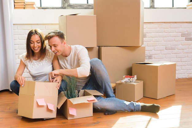 Photo gratuite homme curieux regardant à l'intérieur d'une boîte en carton