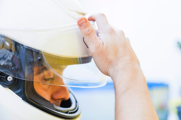 Homme dans le casque en baissant le verre