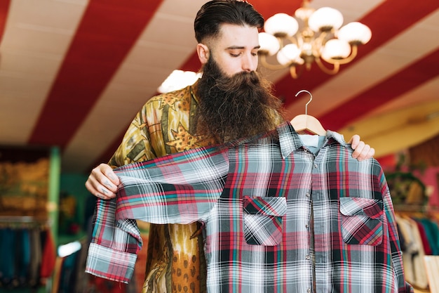 Homme dans un magasin à la mode en vérifiant chemise à carreaux