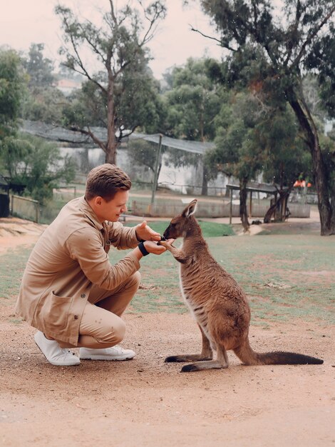 L'homme dans la réserve joue avec un kangourou