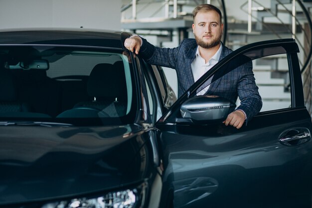 Homme dans la salle d'exposition de voiture en choisissant une voiture