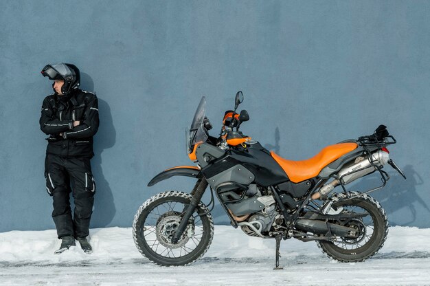 Homme debout à côté de la moto avec casque