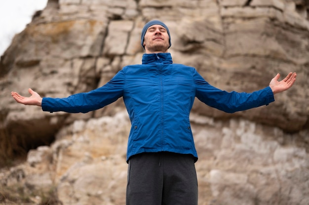 Homme debout dans la nature avec les bras ouverts