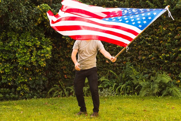 Un homme debout dans le parc agitant un drapeau arménien