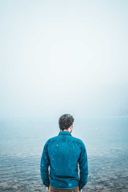 Homme debout devant le plan d'eau