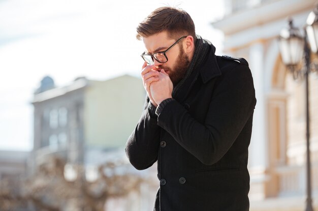 Homme debout et s'inclinant sur les mains à l'extérieur par temps froid