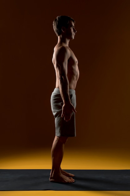 Homme debout sur un tapis de yoga