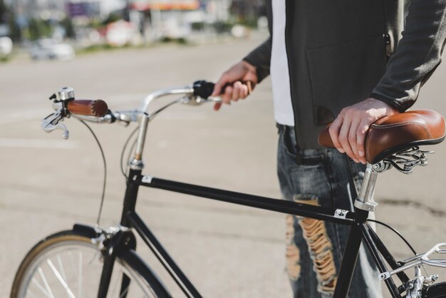 Homme debout avec vélo sur route