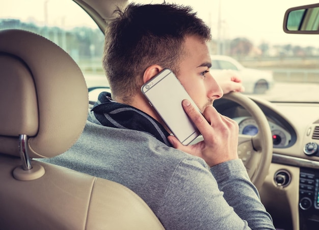 Homme Décontracté Parlant Par Smartphone Dans La Voiture.