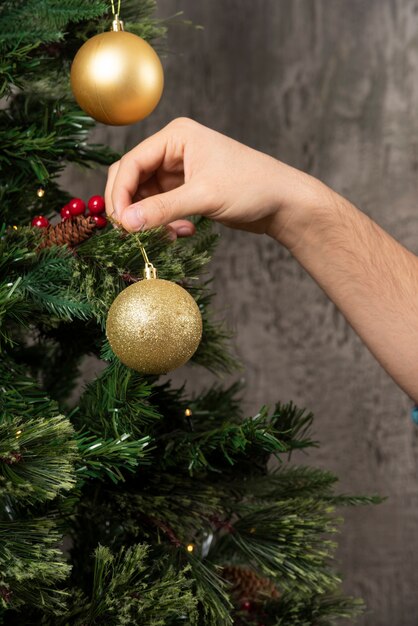 Un homme décorant un sapin de Noël.