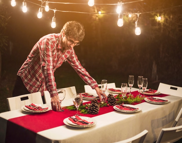 Photo gratuite homme décorant une table avec des boules de fête