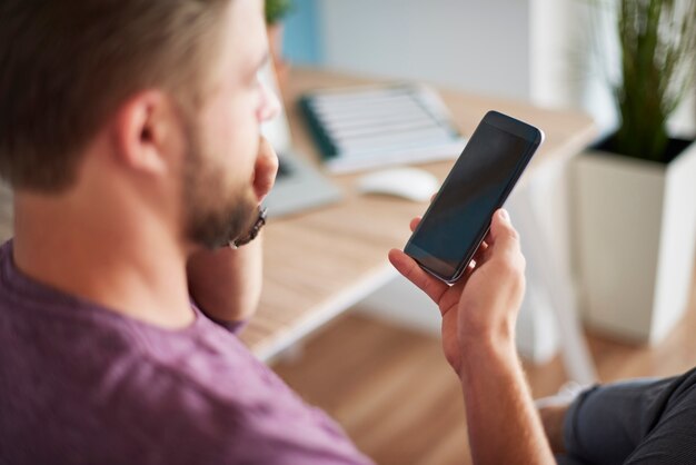 Homme défocalisé et son téléphone portable