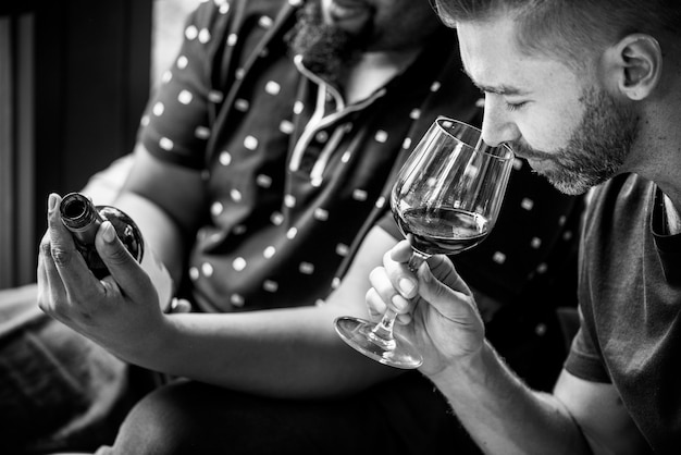 Homme dégustant du vin rouge avec des amis