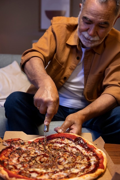Homme dégustant une pizza tout en étant seul à la maison