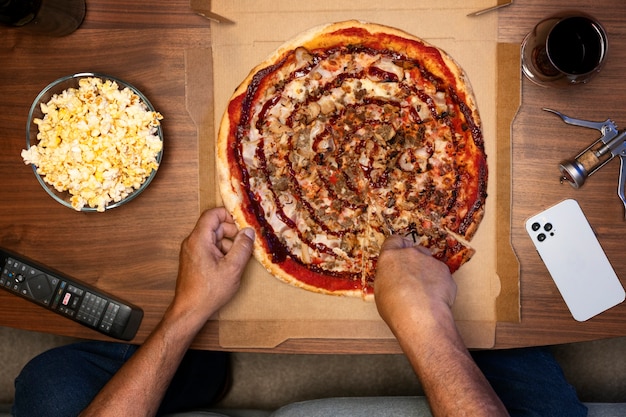 Homme dégustant une pizza tout en étant seul à la maison