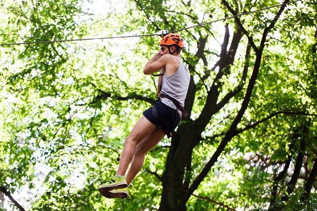 L&#39;homme descend sur la corde dans un parc de divertissement