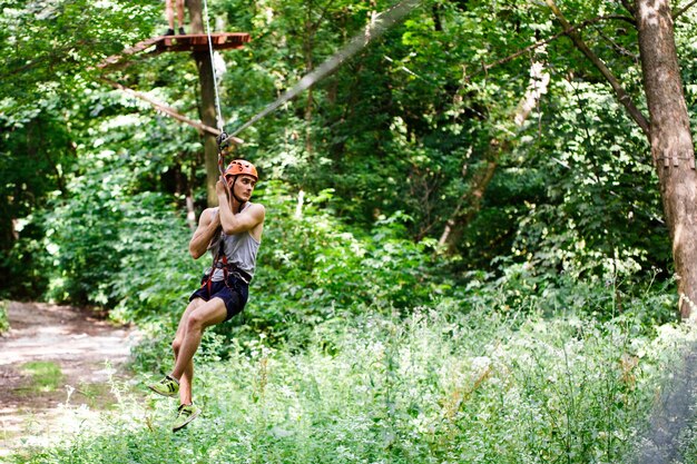 L&#39;homme descend sur la corde dans un parc de divertissement