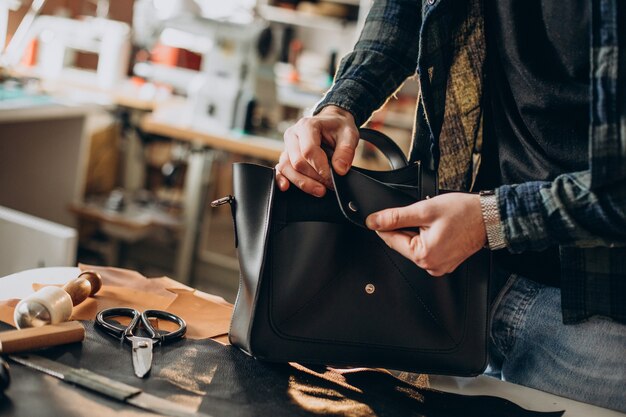 Homme designer et tailleur en cuir travaillant dans une usine close up