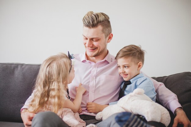 Un homme détendu assis avec ses enfants