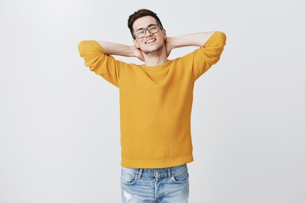 Homme détendu insouciant tenir la main derrière et souriant, au repos