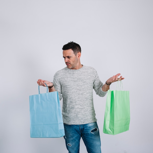 Photo gratuite homme avec deux sacs à provisions