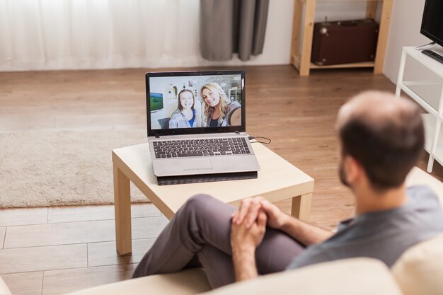 Homme discutant avec sa famille lors d'un appel vidéo en temps de pandémie mondiale.