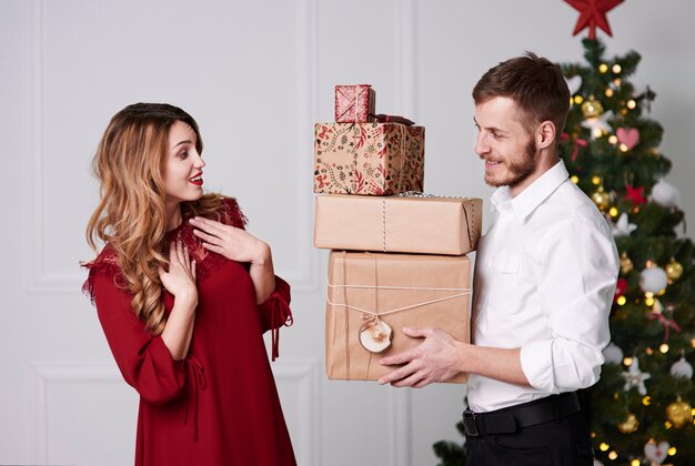 Homme donnant pile de cadeaux à la femme