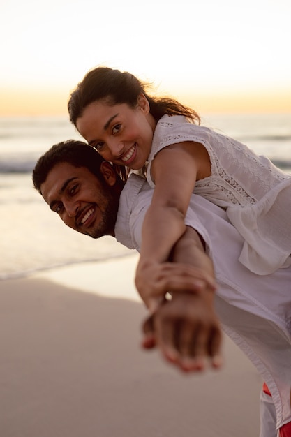 Homme donnant une promenade sur la plage avec une femme