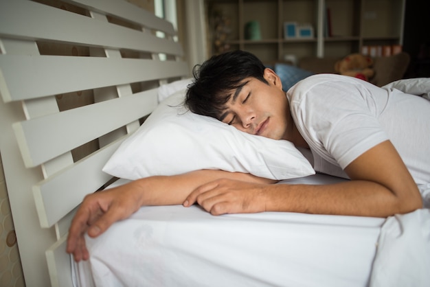 Homme dormant sur le lit le matin