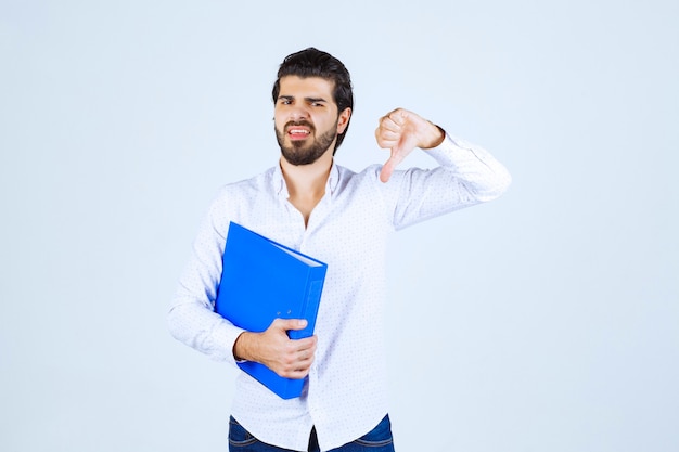 L'homme avec un dossier bleu a l'air épuisé et insatisfait