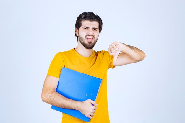 Homme avec dossier bleu faisant le pouce vers le bas.