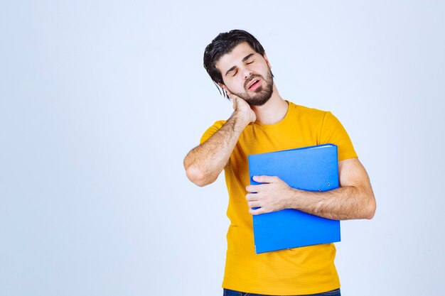 L'homme avec un dossier bleu semble confus ou inexpérimenté.