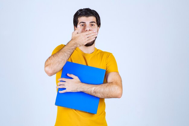 L'homme avec un dossier bleu semble confus ou inexpérimenté.